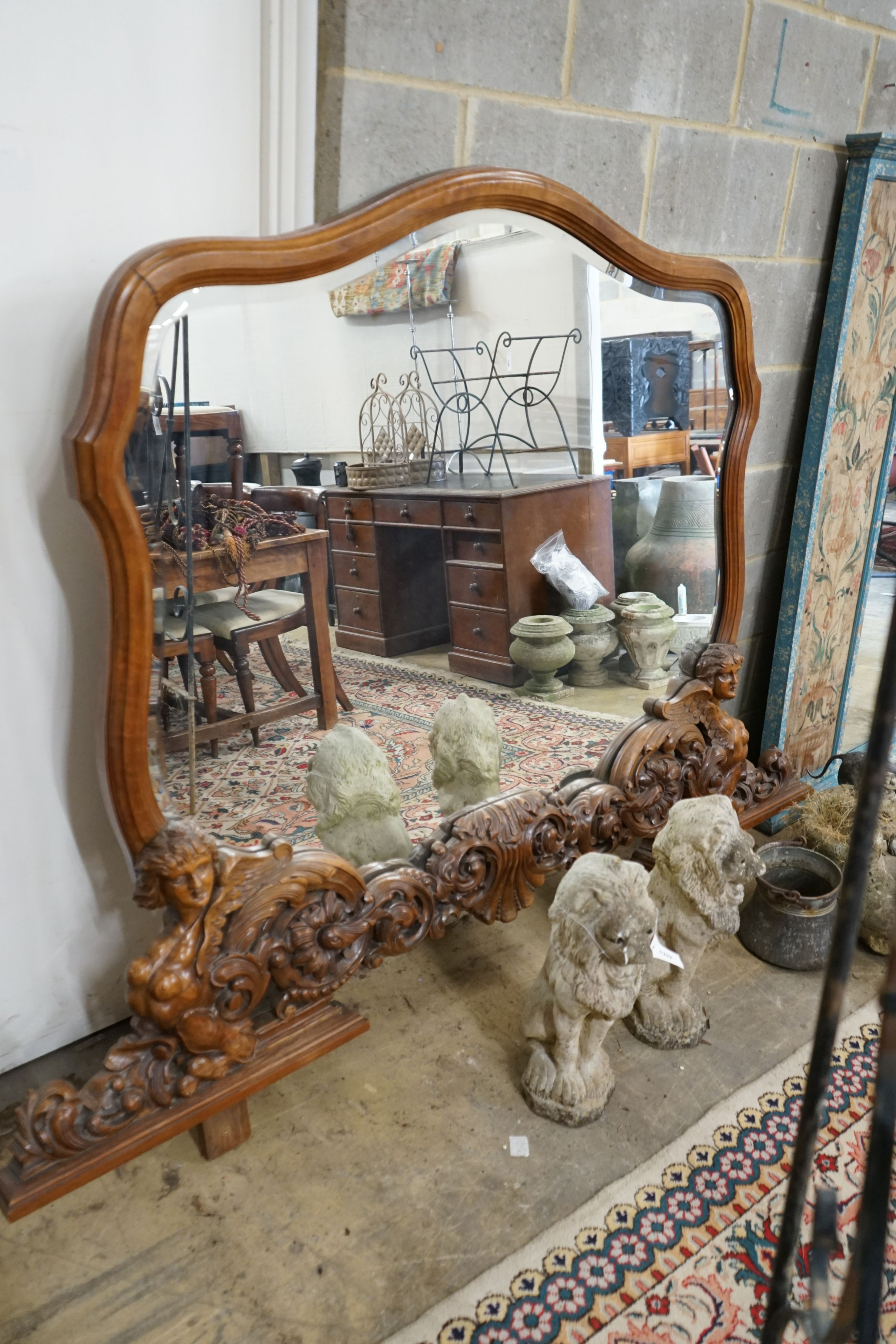 A near pair of Italian style carved walnut overmantel mirrors, decorated with winged figures, scrolls and scallop shells, larger width 200cm, height 152cm